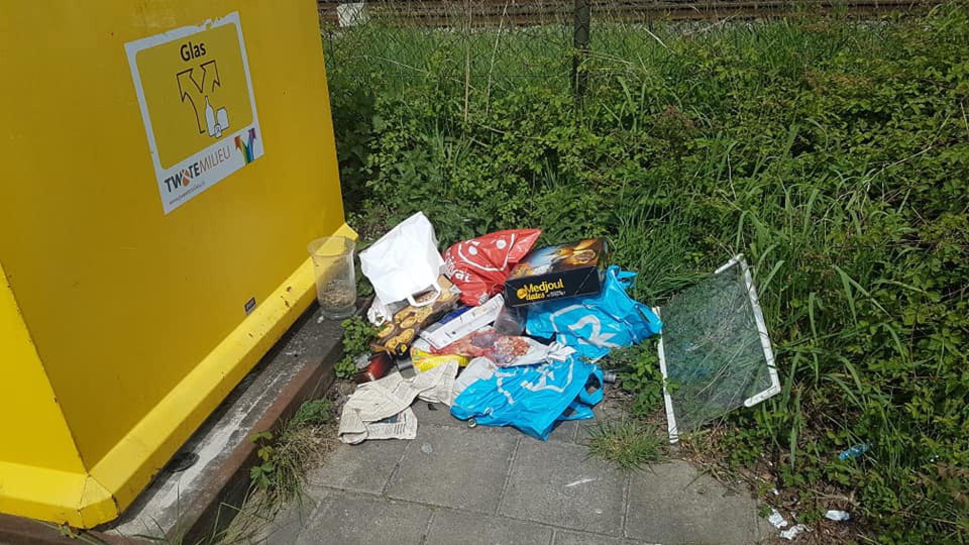 Ergernis over afvaldump bij glasbak bij spoorwegovergang Bernhardstraat