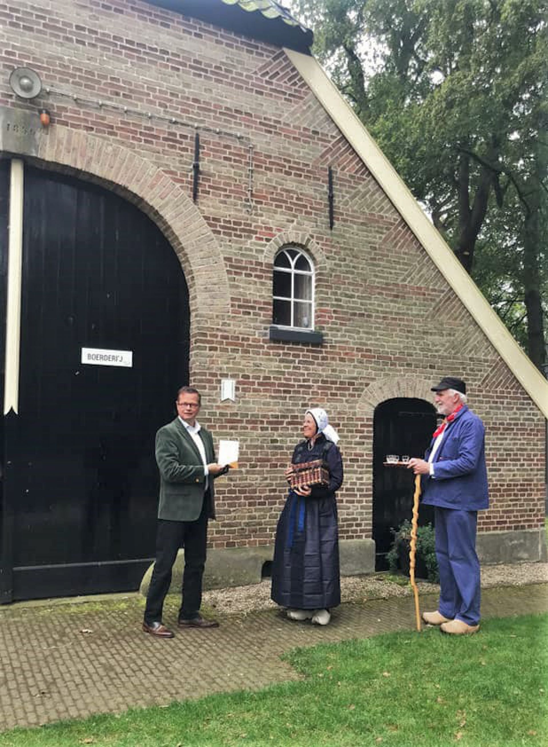 Wethouder plaatst monumentenschildje bij Museumboerderij Wendezoele 