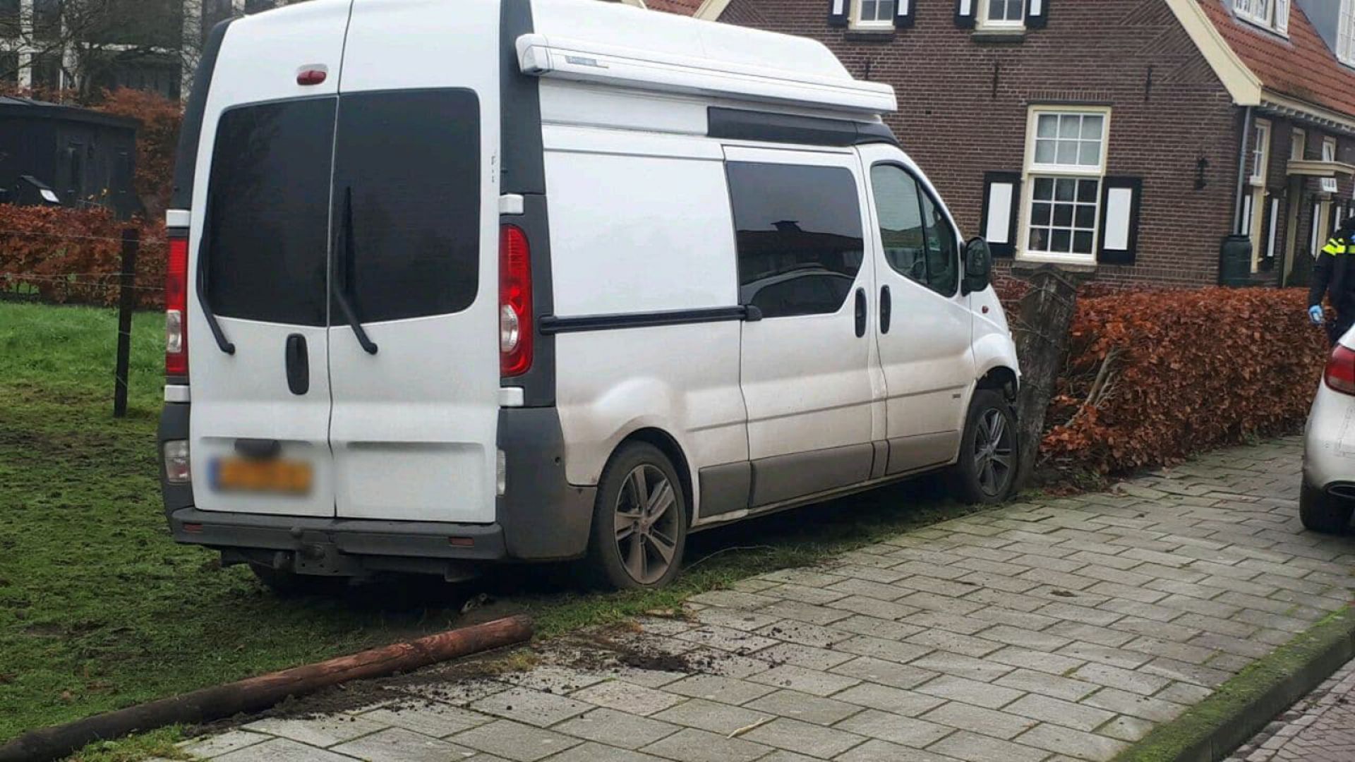 Camper ramt palen en komt tegen heg tot stilstand